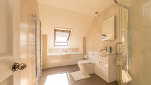 A modern bathroom with a bathtub, toilet, and shower. - Pet Friendly Farm Stay with Hot Tub Pembrokeshire | Clematis-Y-Ffynnon (Pembrokeshire)