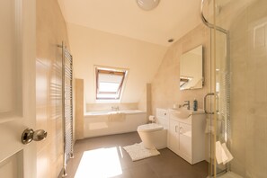 A modern bathroom with a bathtub, toilet, and shower. - Pet Friendly Farm Stay with Hot Tub Pembrokeshire | Clematis-Y-Ffynnon (Pembrokeshire)