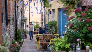 A narrow alley with outdoor seating, brick walls, and hanging decorations. - Pet Friendly Farm Stay with Hot Tub Pembrokeshire | Clematis-Y-Ffynnon (Pembrokeshire)