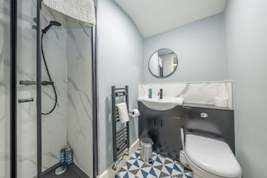 A bathroom with a shower, toilet, sink, and a mirror. - Ffawydd-Y-Ffynnon -  a self catering cottage that sleeps 6 guests  in 3 bedrooms (Llanfyrnach)