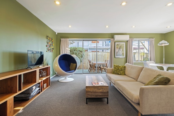 A living room with a television, a bean bag chair, a sofa, and a coffee table.