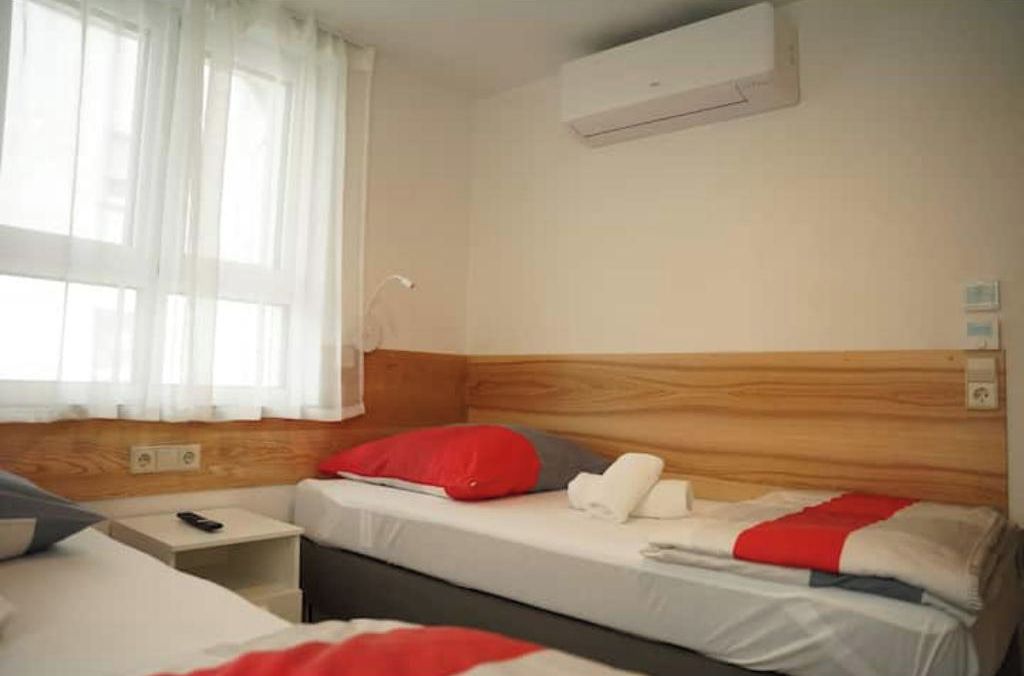 Ein Hotelzimmer mit Bett, Nachttisch und Klimaanlage.