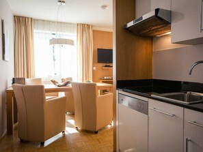 Una cocina moderna con lavavajillas, un lavamanos y un televisor de pantalla plana montado en la pared.