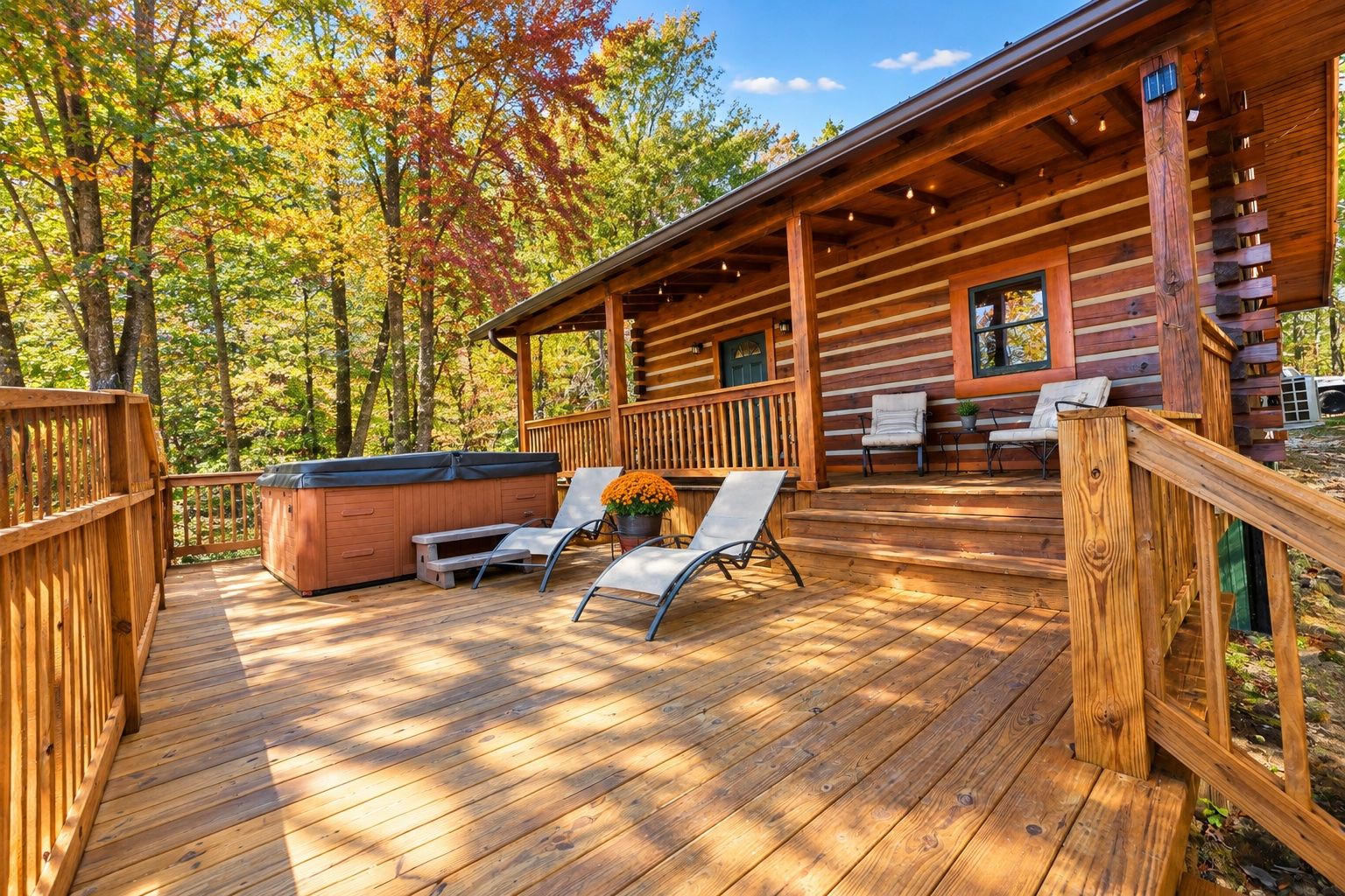 A wooden deck with outdoor seating and a hot tub.