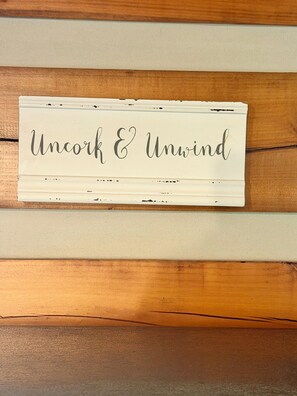 Une enseigne avec l’inscription « Dégustez et détendez-vous » sur un mur en bois.