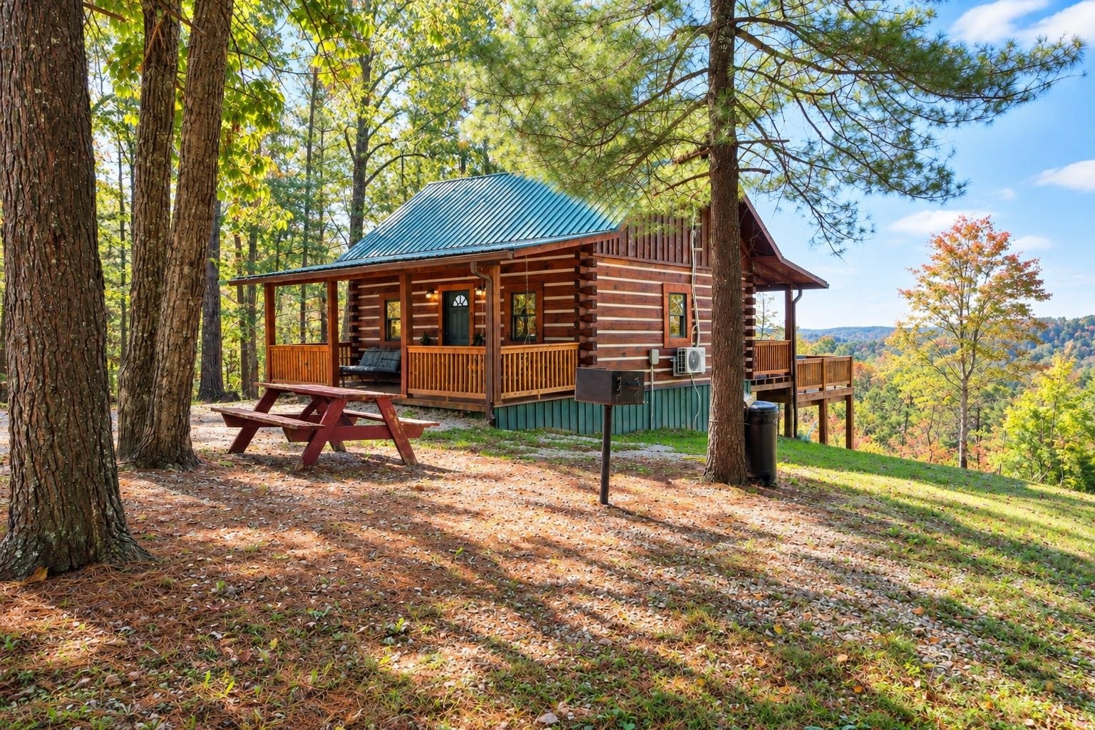 A rustic cabin with a wooden deck, a picnic table, and a metal roof.