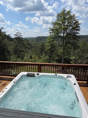 A hot tub on a wooden deck with a forest view. - NEW LISTING PROMO Sunset Bluff Overlook Cabin in the RRG•
Hot Tub• Fireplace (Pine Ridge)
