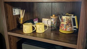 A wooden shelf with a duck figurine, a book titled 'Lawrence County History Trivia,' and a coffee maker.