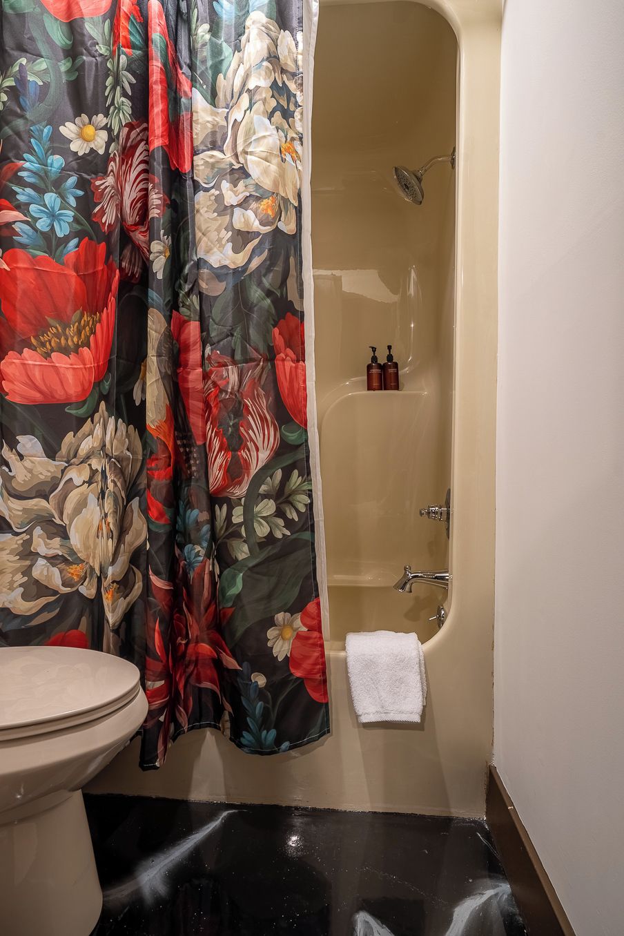 A bathroom with a bathtub, toilet, and shower curtain.