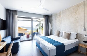 A modern hotel room with a large bed, a seating area with a table, and a view of the outdoors. - Exquisite Nikiana Villa with Sea Views and Pontoon Access near Tavernas (Lefkada)