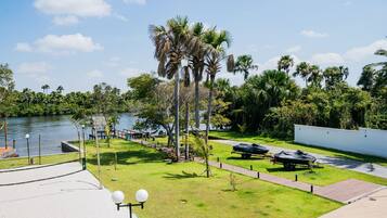 A waterfront park with palm trees, a walking path, and a boat trailer.