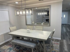 A dining room with a large mirror, a chandelier, and a bench. - Spacious Home with Game-room,  close to SeaWorld. (San Antonio)