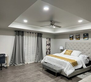 A modern bedroom with a bed, a desk, and a ceiling fan. - Spacious Home with Game-room,  close to SeaWorld. (San Antonio)