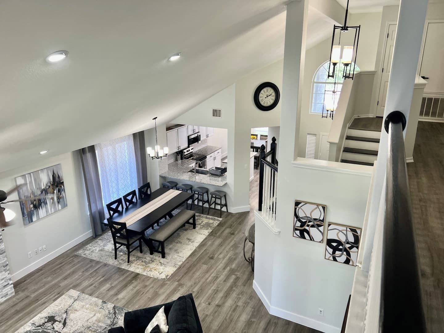 A spacious living area with a dining table, kitchen, and staircase.