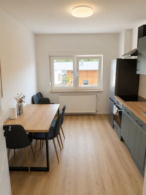 Eine moderne Küche mit Essbereich, einem Fenster mit Aussicht und einem eingebauten Backofen.