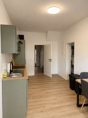 A modern kitchen with a built-in dishwasher, a sink, and a wooden countertop. - Mühlhausen Ground Floor Apartment for Workers and Vacationers (Mühlhausen)