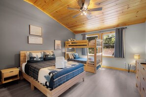 A bedroom with a bunk bed, a single bed, wooden headboard, a ceiling fan, and a window with curtains. - The West Nest - Ellijay,GA (Ellijay)