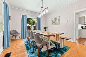 Ein Essbereich mit einem Holztisch, Stühlen und einem blau gemusterten Teppich.