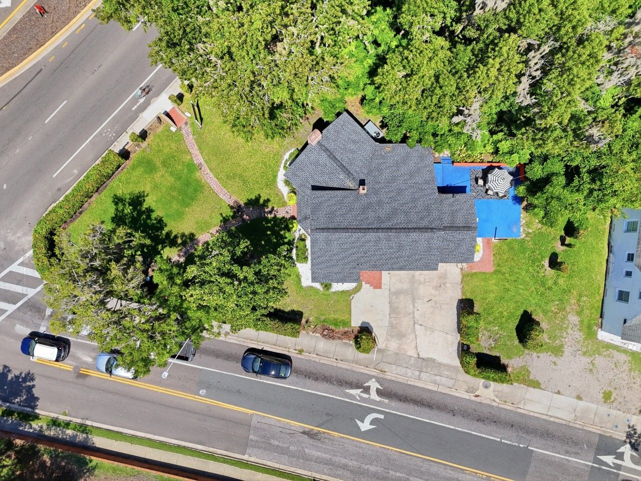 Vue aérienne d’un quartier résidentiel avec une maison, une allée et une route.