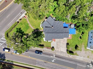 An aerial view of a residential area with a house, a driveway, and a road. - Walk to UF  Shands Ultimate Tailgate House (Gainesville)