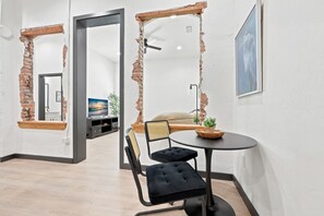 A room with a brick wall, a black sofa, a round table, and a hanging chair. - High Springs Downtown | Steps to Dining & Shops (High Springs)
