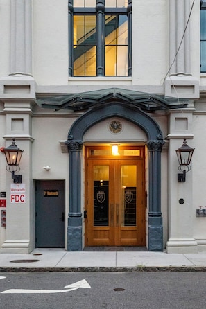 A building with a prominent entrance featuring a wooden door and a coat of arms above it.