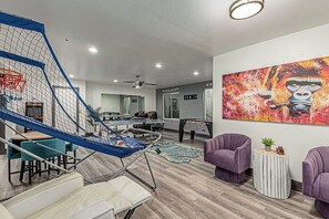 A recreational area with a foosball table, a ping pong table, and a slide. - Elite Luxury Pickleball Palace-Heated Pool (Scottsdale)
