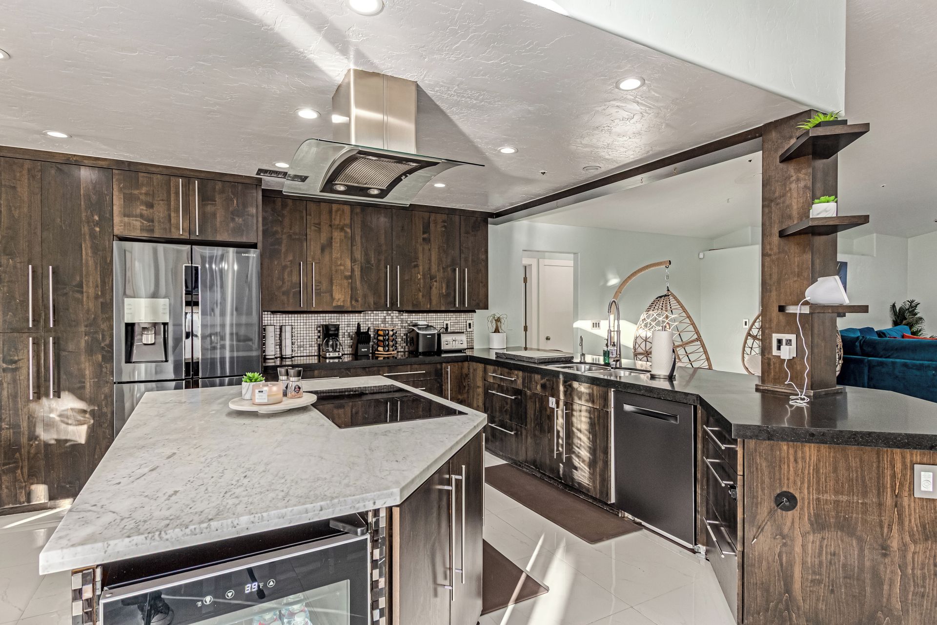 A modern kitchen with a central island, stainless steel appliances, and wooden cabinetry.