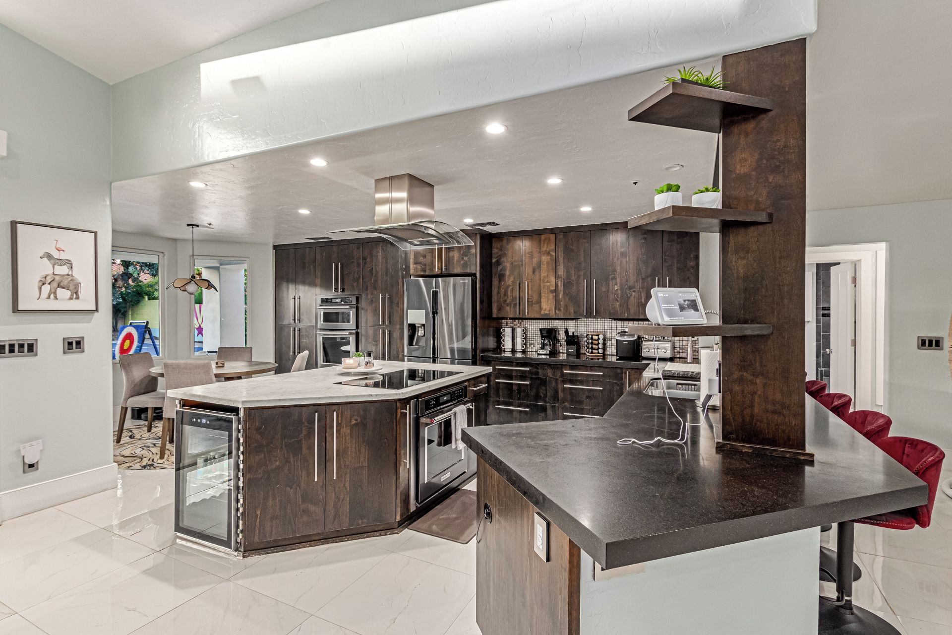 Una cocina moderna con gabinetes de madera oscura, electrodomésticos de acero inoxidable y una isla central.