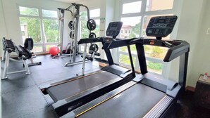 Una palestra con tapis roulant, macchinari per pesi e un'ampia vetrata.