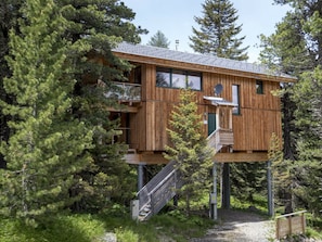 A wooden cabin with a balcony, surrounded by trees. - Cabin in Turrach With Sauna and Balcony (Stadl-Predlitz)