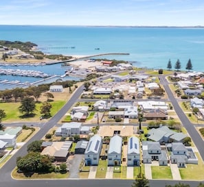 A coastal residential area with houses, a marina, and a bridge. - Coastal luxury home with breathtaking ocean and harbour views (Robe)