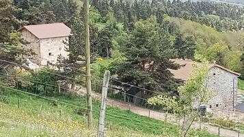 Un paysage rural avec des bâtiments en pierre, une route et une clôture.