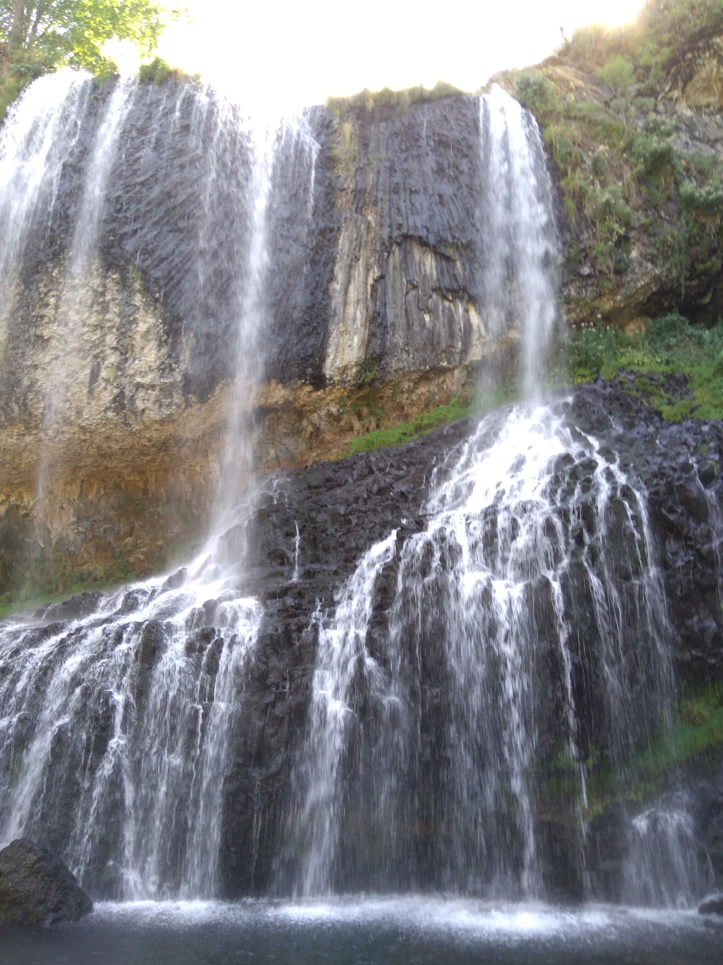 Una cascada que se precipita sobre un acantilado rocoso.