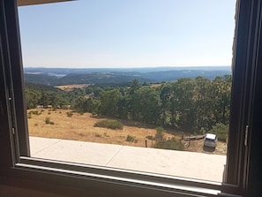 Une vue sur un paysage, avec une route et un véhicule, à travers une fenêtre.