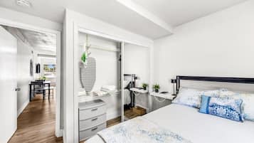 A modern bedroom with a bed, bedside tables, and a wardrobe.