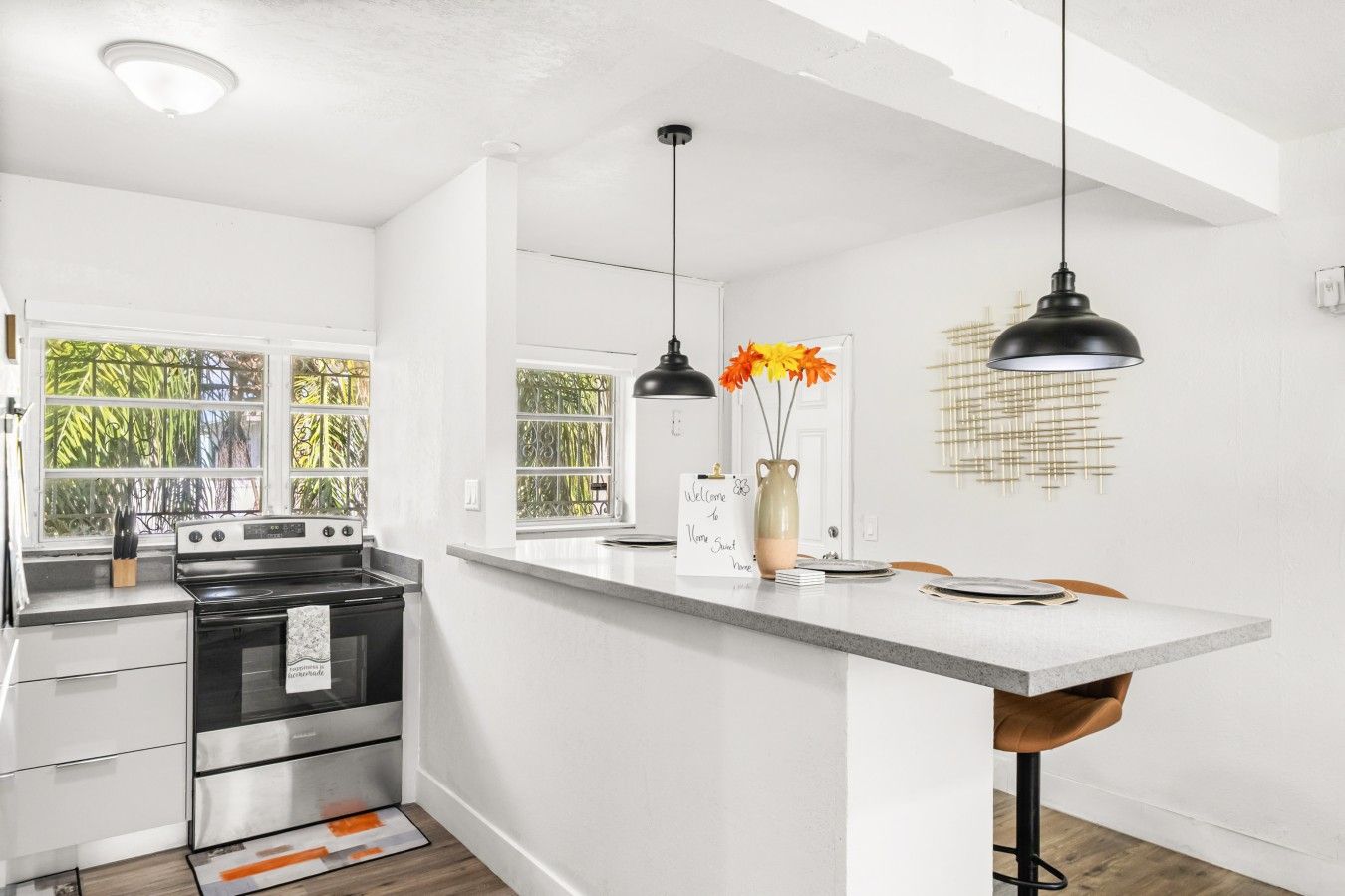 A modern kitchen with a central island, stainless steel appliances, and pendant lighting.