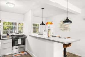 A modern kitchen with a central island, stainless steel appliances, and pendant lighting.