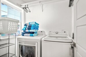 Un espace buanderie avec des piles de serviettes, un lave-linge et un sèche-linge.