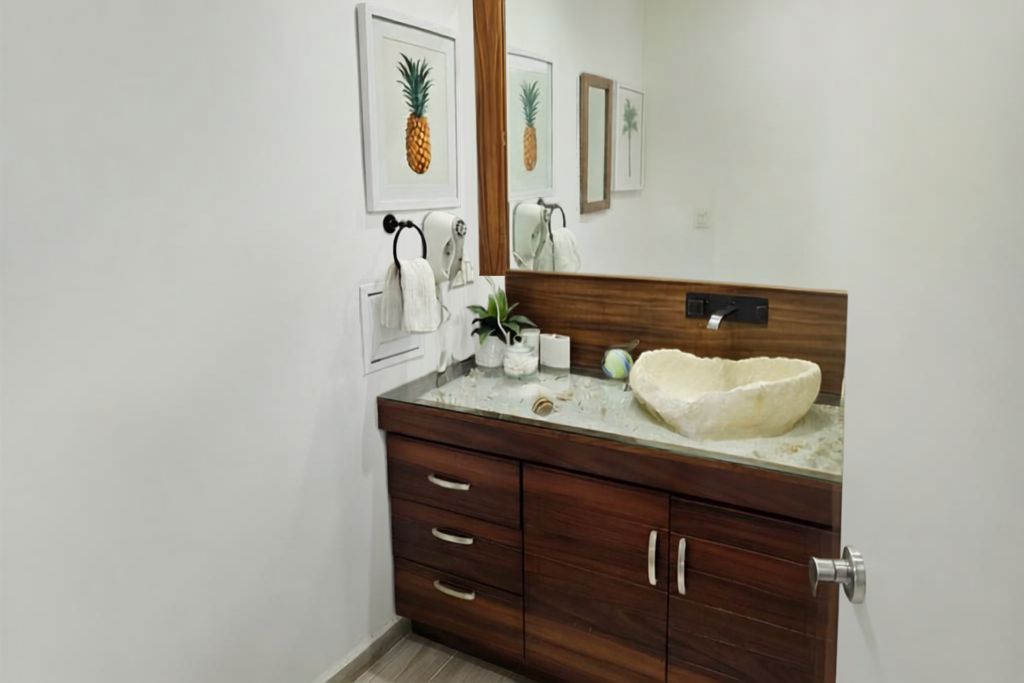 Un baño con tocador de madera, un espejo grande y un lavabo.