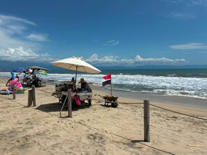 A beach with a cart, a flag, and a beach umbrella. - Fabulous Presidential Suite with AC and full kitchen  in sunny Nuevo Nayarit (Nuevo Nayarit)