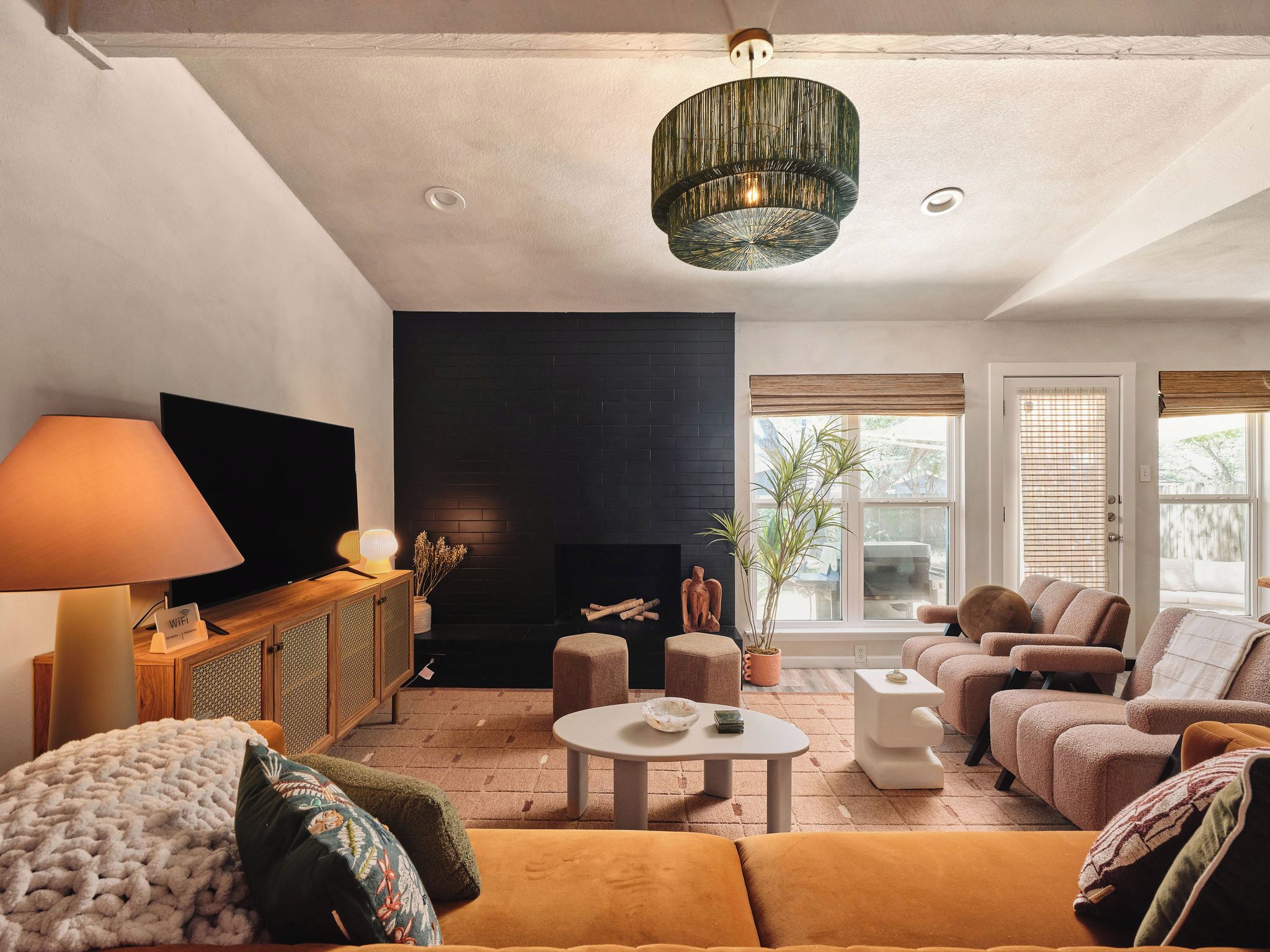 A living room with a fireplace, sofa, armchairs, and a television.