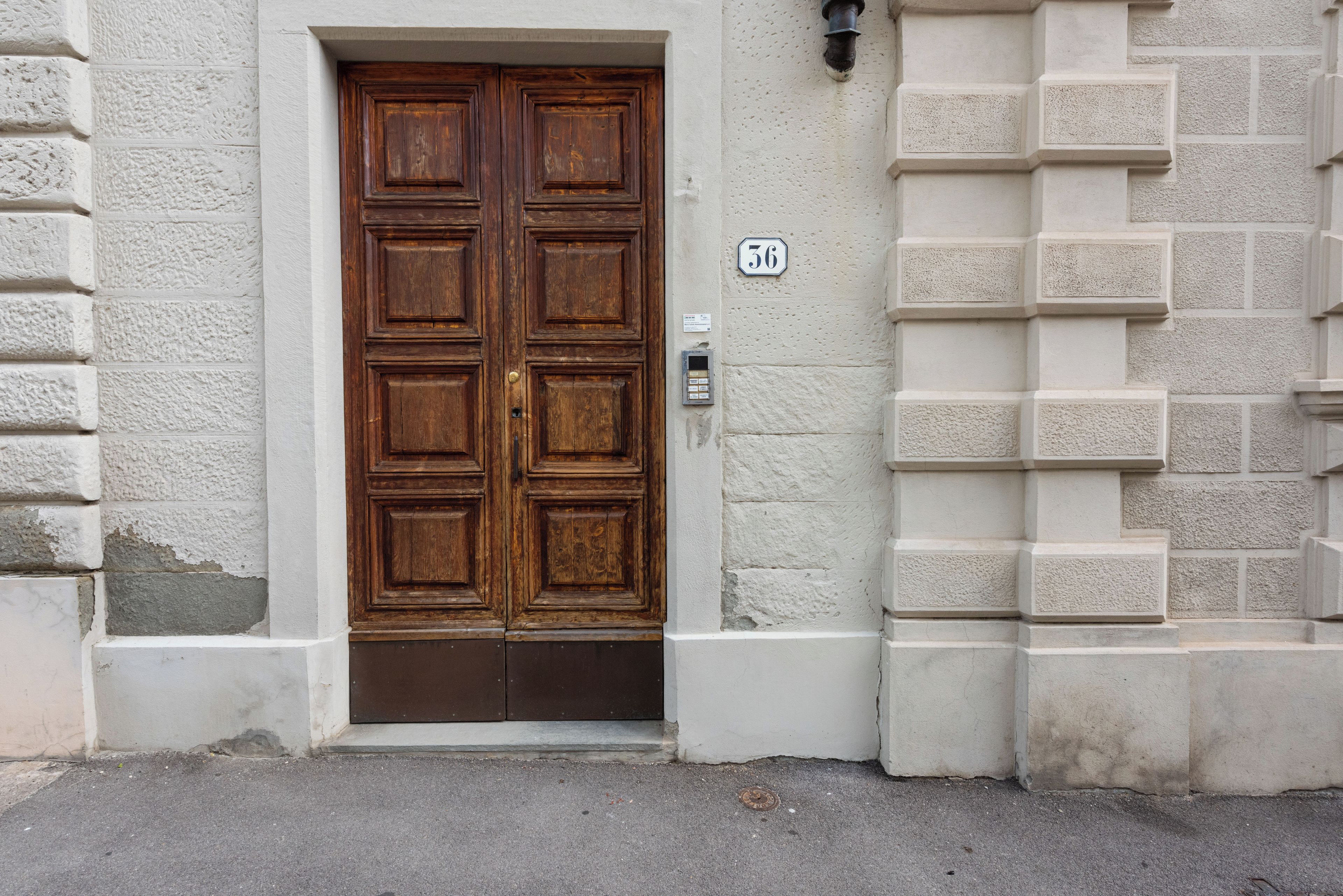 A wooden double door with a small mailbox on the right side.