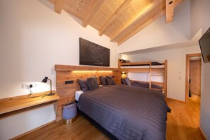 A bedroom with a bunk bed, a desk with a lamp, and a large painting on the wall. - Superb 9-bedroom chalet in alpine Zillertal for your getaway or wintersports (Hochkrimml)