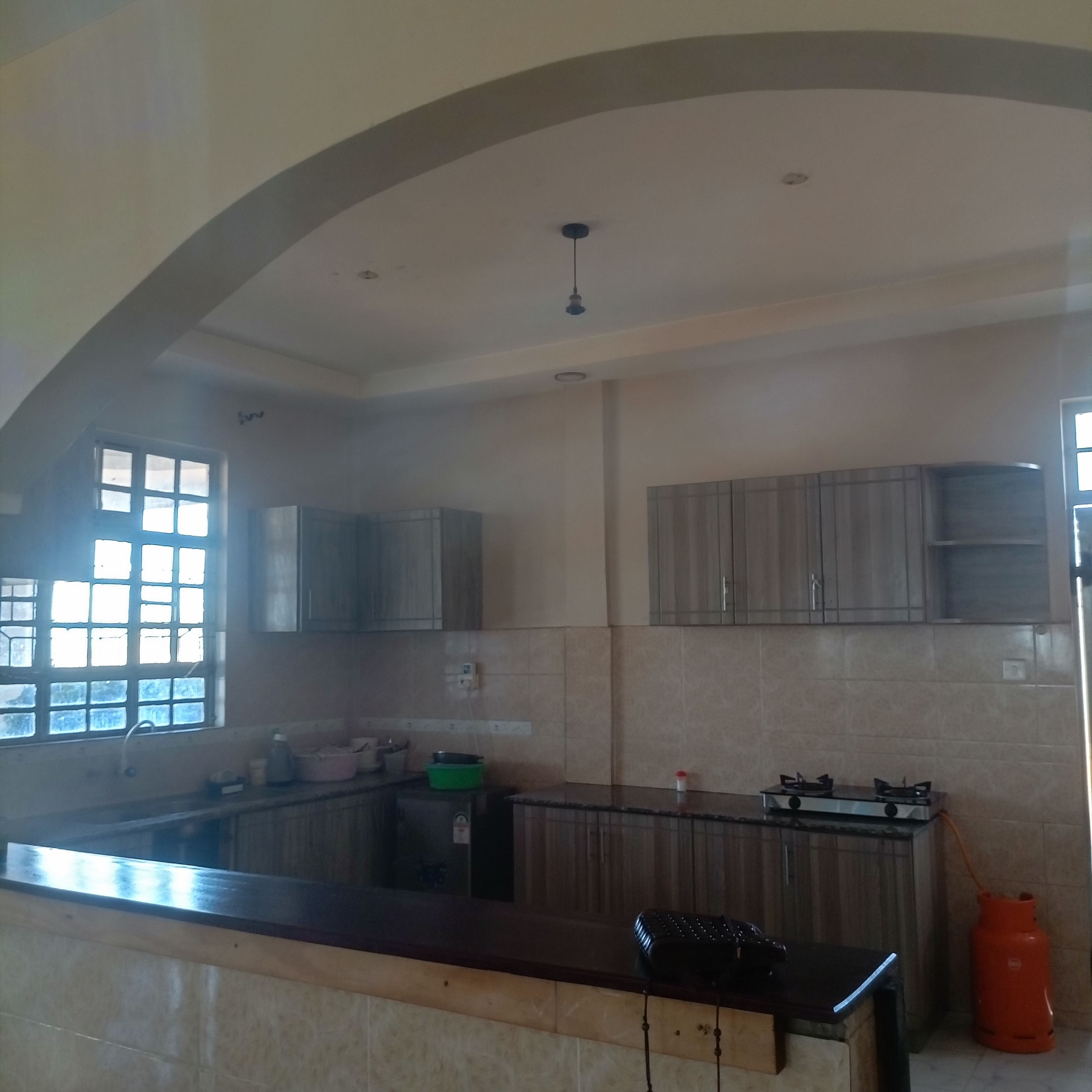 A kitchen with a built-in stove, cabinets, and a window.