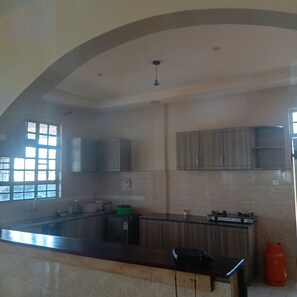Una cocina con estufa integrada, armarios y ventana.
