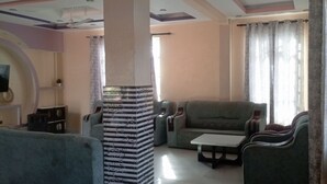 A living room with sofas, a coffee table, and a decorative pillar. - Adorable 4-bedroom bungalow in terrific Taita Taveta location (Taita Taveta)