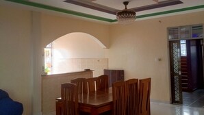 A dining area with a wooden table and chairs, a chandelier, and a tiled backsplash. - Adorable 4-bedroom bungalow in terrific Taita Taveta location (Taita Taveta)