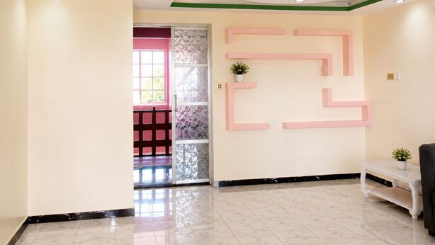 A modern interior with a marble floor, a reception desk, and a decorative wall with geometric patterns. - Adorable 4-bedroom bungalow in terrific Taita Taveta location (Taita Taveta)