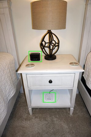 A white nightstand with a lamp, a clock, and a power strip. - COMPLETELY RENOVATED! Newly furnished 2 bedroom condo in the heart of St. Simons (St. Simons Island)